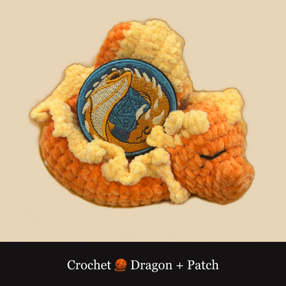 A crocheted dragon patch with cream-colored yarn body, orange-red scales, and a blue circular embroidered patch in the center showing a gold dragon design. The patch is displayed on a beige background with a black banner at the bottom reading 'Crochet Dragon + Patch'.